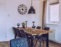 a living room with a clock at the top of a wooden table
